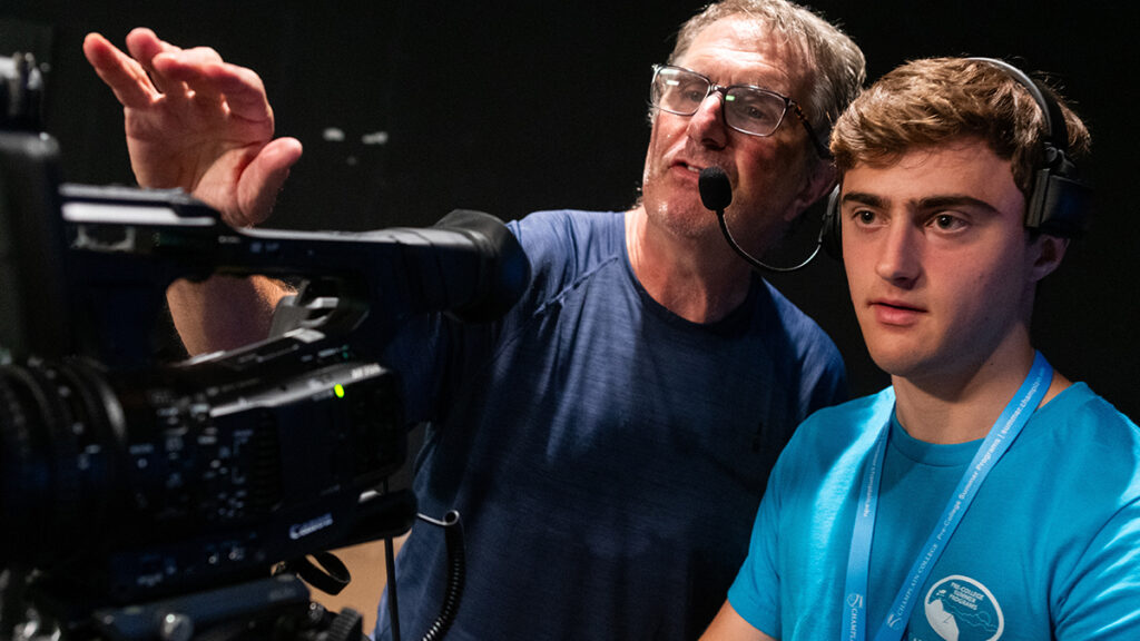 Instructor helping student work a camera