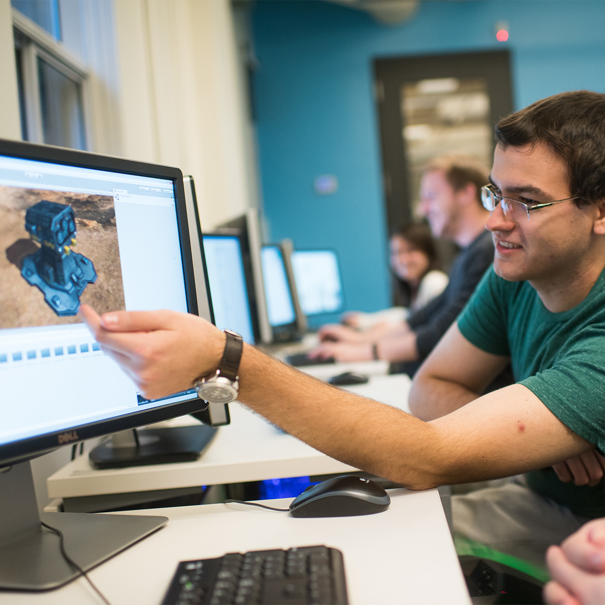 Student showing an animated robot to another student on a computer screen