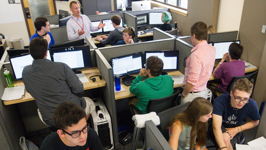 Student's and Faculty Discuss Computer Science and Technology in a classroom setting.
