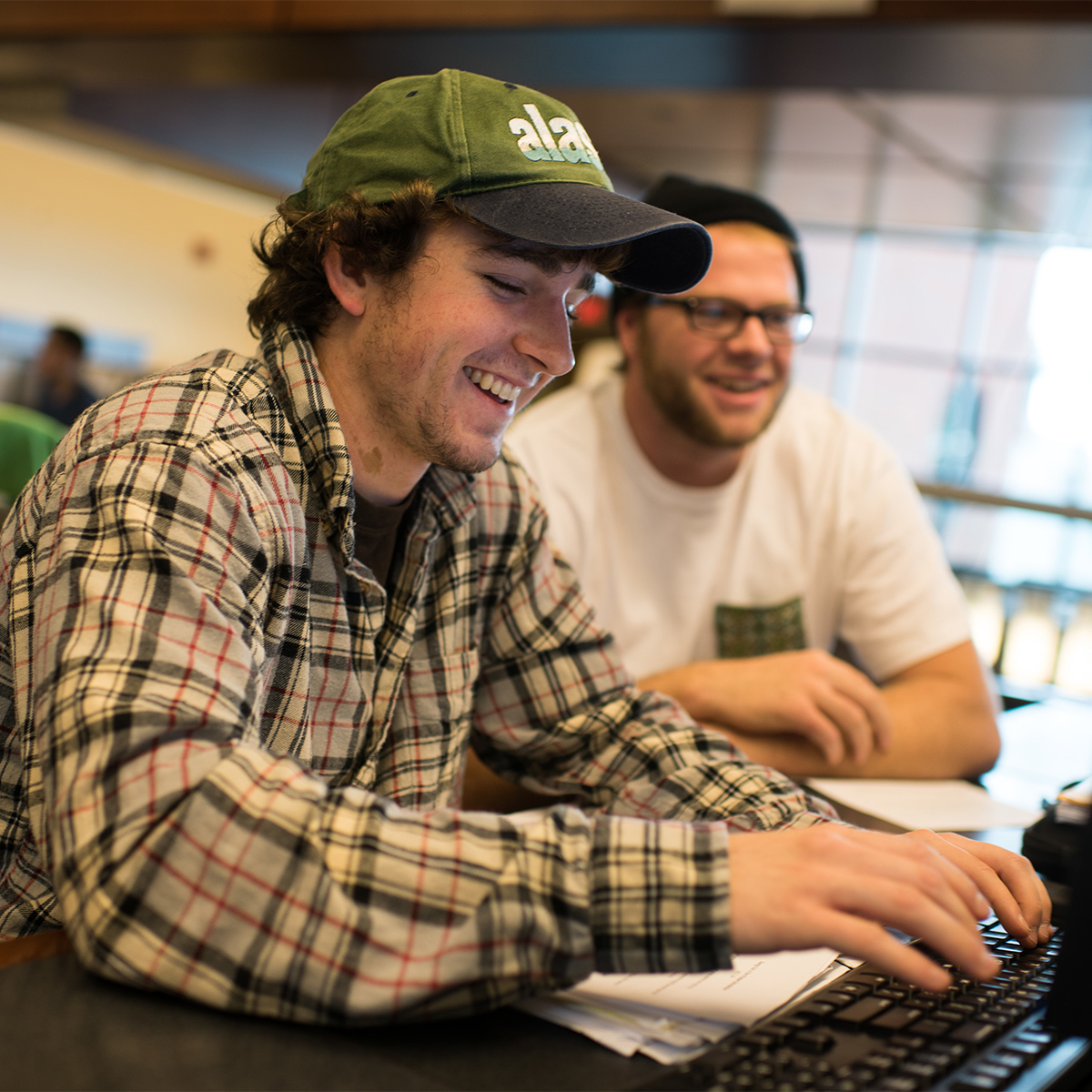 Students laughing and working on a computer