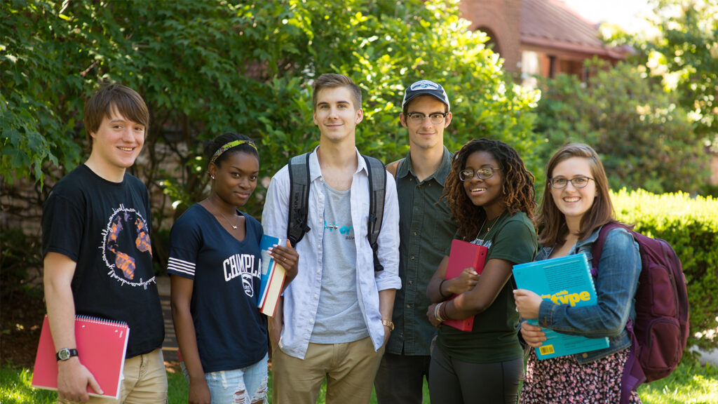 Smiling students standing on a lawn