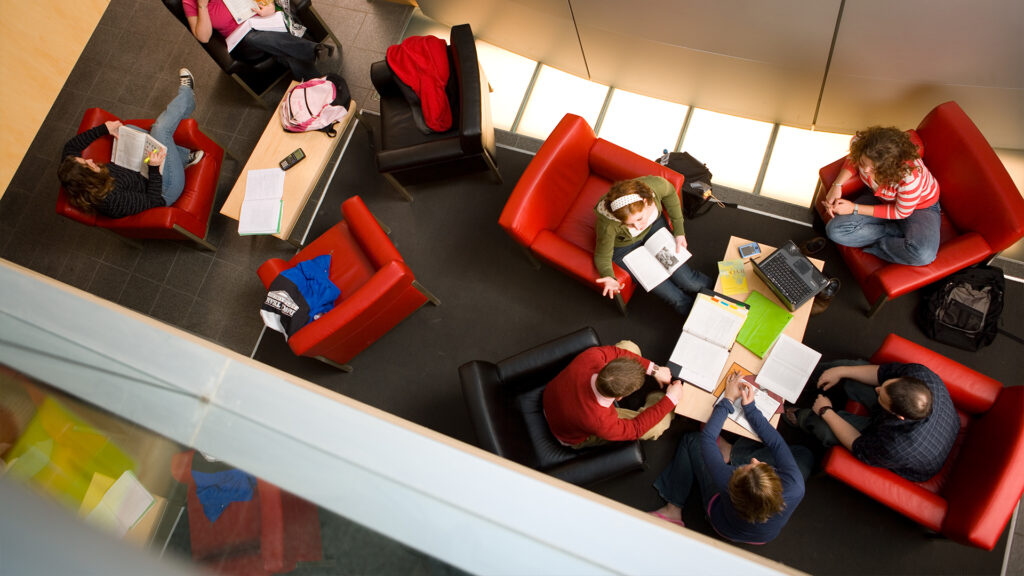 Aerial view of students sitting in lounge doing class work