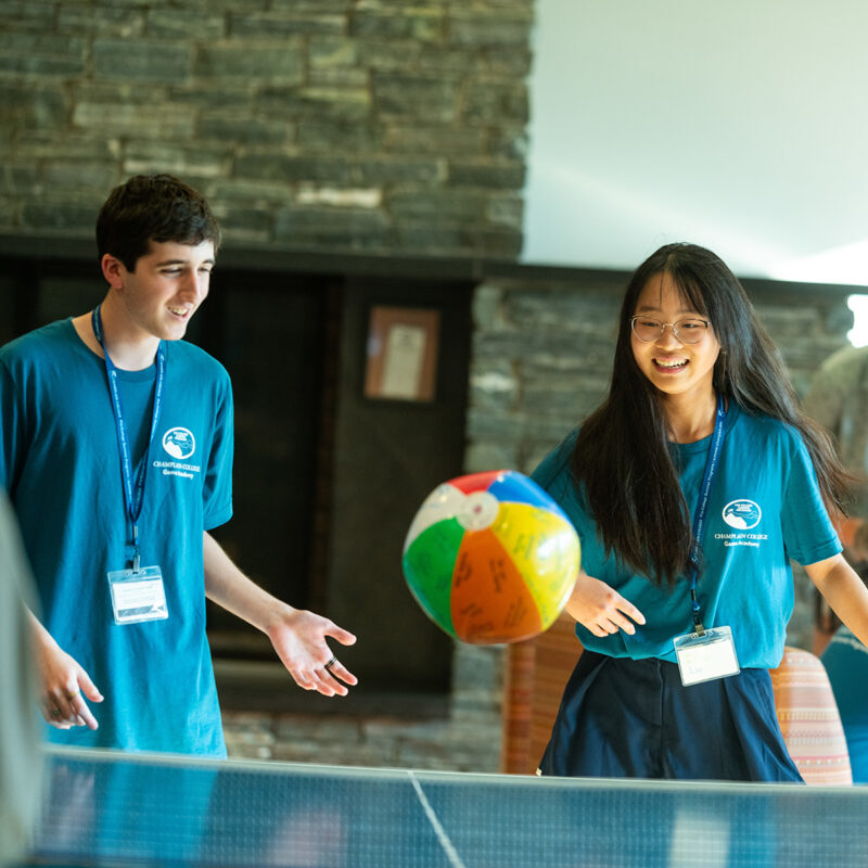 Students hitting a beach ball over a ping pong table