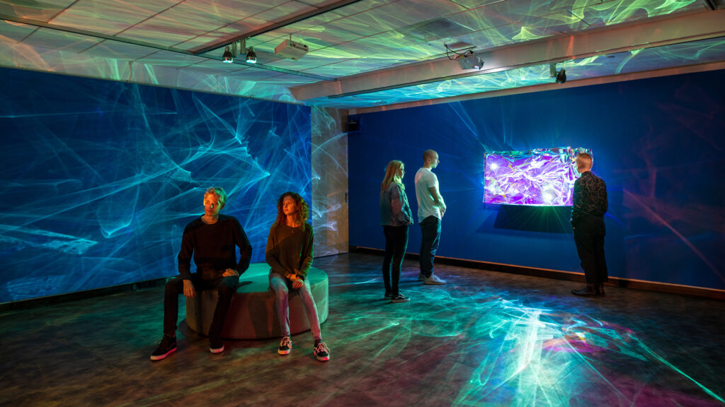 Students in a room with laser projections on wall