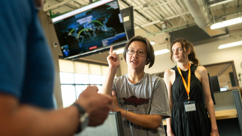 a cybersecurity pre-college students converses with faculty in the leahy center